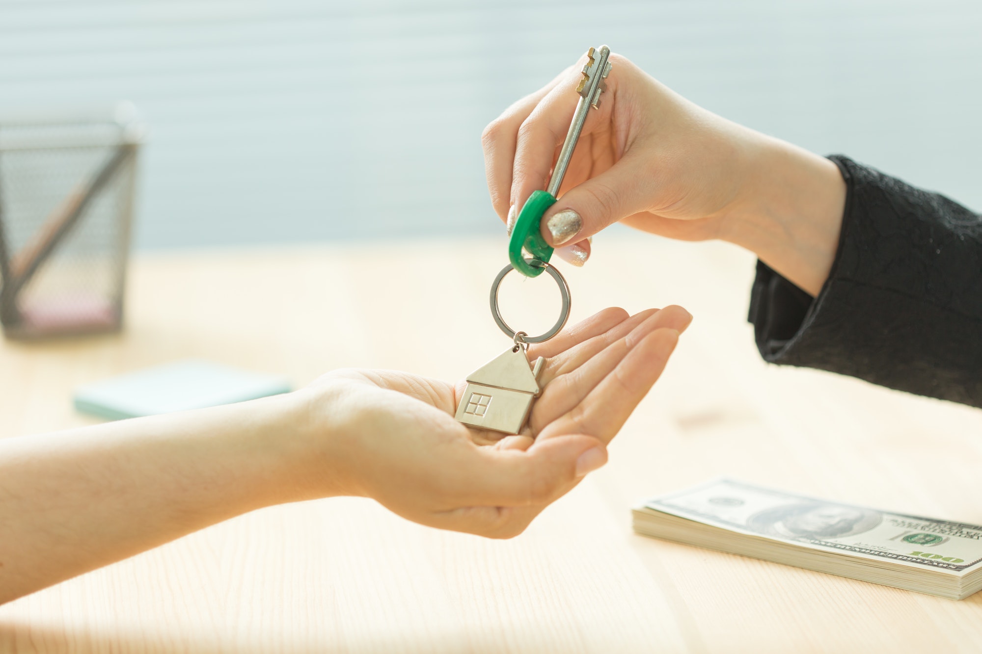 Business, realtor and real estate concept - Hand-to-hand key from new home